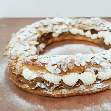 Paris-Brest choux ring filled with hazelnut and almond praline cream, dusted with icing sugar